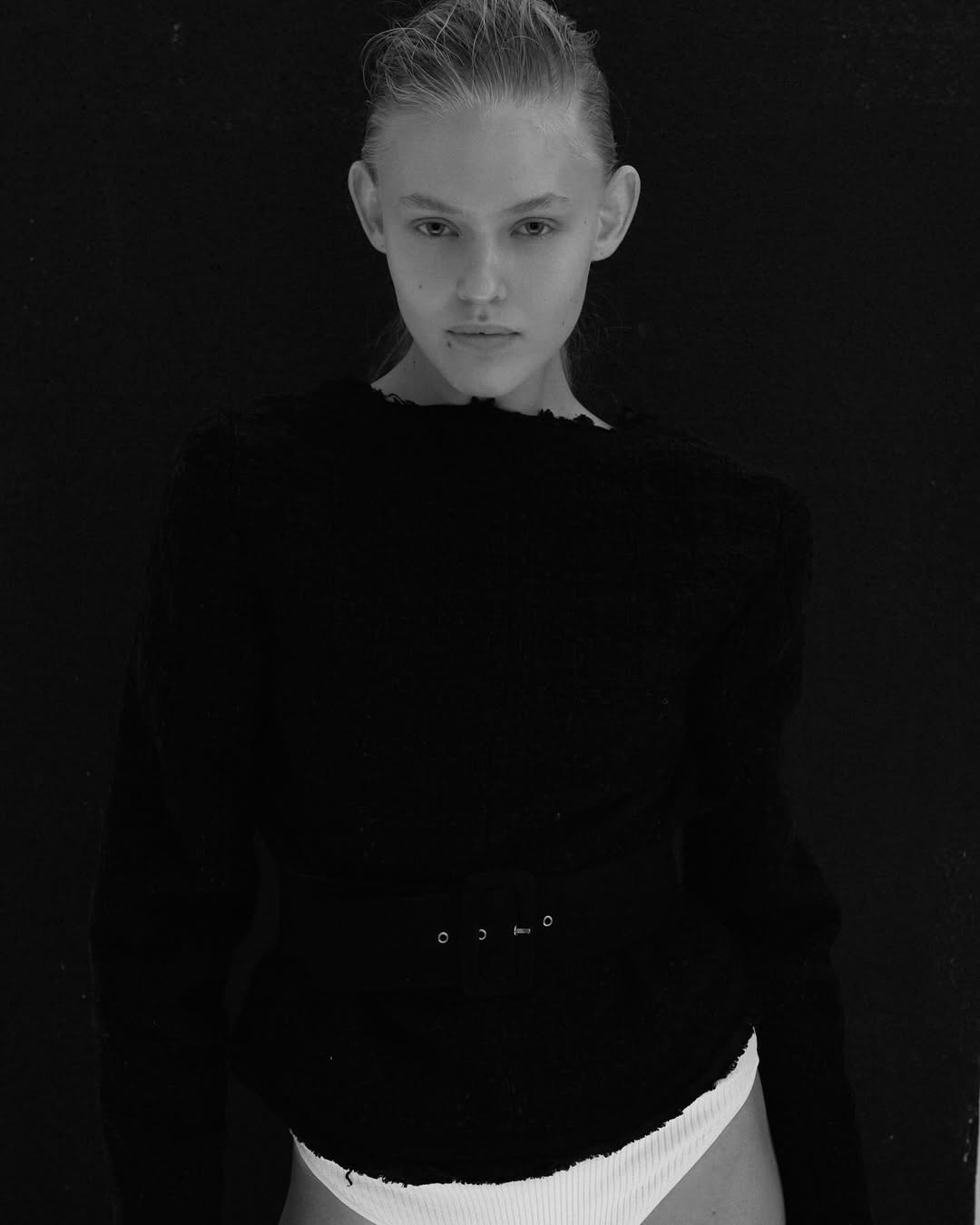 Dark studio, slicked hair